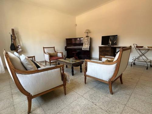 ein Wohnzimmer mit 2 Stühlen und einem Klavier in der Unterkunft ItaloPiano in Guaymallen