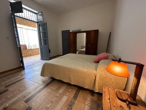 ein Schlafzimmer mit einem Bett und einer Lampe auf einem Holzboden in der Unterkunft ItaloPiano in Guaymallen