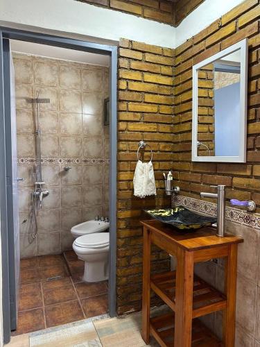 a bathroom with a toilet and a sink and a mirror at PianoHouse in Guaymallen