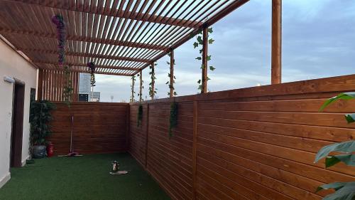 a patio with a wooden fence and a wooden pergola at نجد هاوس - نساء فقط Ladies Hostel in Riyadh