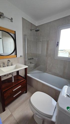 a bathroom with a tub and a toilet and a sink at Departamento Villarino in Puerto Madryn