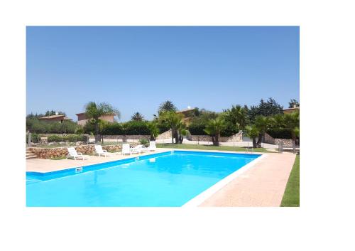 una piscina azul con sillas y árboles en ViViHolidays, en Castellammare del Golfo