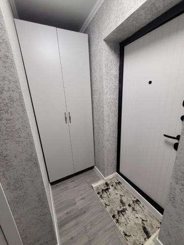 um quarto com armários brancos e uma porta em Апартаменты посуточно em Temirtaū