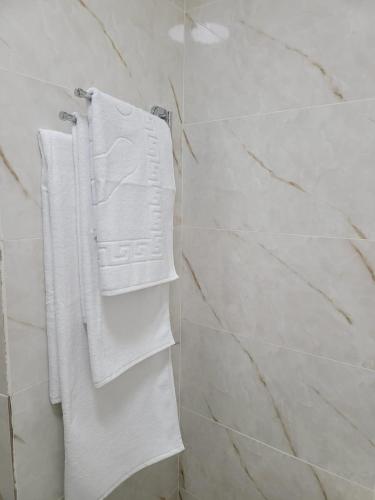 un baño con toallas blancas en un toallero. en Апартаменты посуточно, en Temirtaū