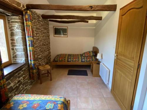 1 dormitorio con 1 cama en una pared de piedra en Ô Gites du Visaret, en Connac