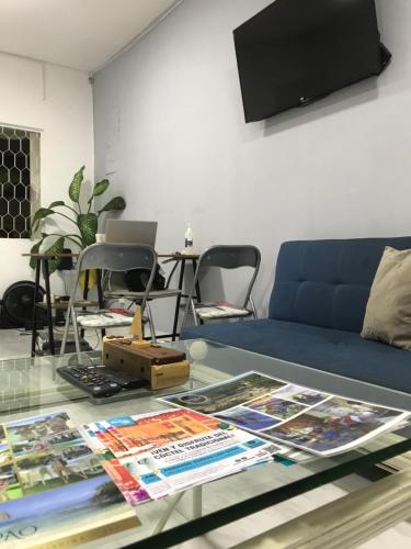 ein Wohnzimmer mit einem blauen Sofa und einem Glastisch in der Unterkunft Casa Encanto Manga in Cartagena de Indias