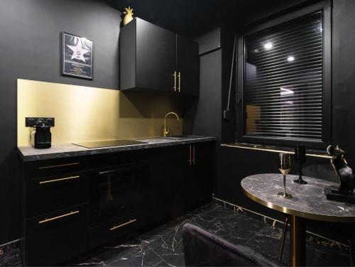 una cucina con armadi neri, tavolo e finestra di Vegas Room - Luxury a Serémange-Erzange
