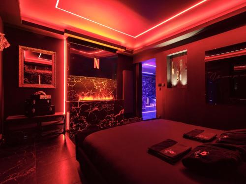 una camera con letto e illuminazione rossa di Vegas Room - Luxury a Serémange-Erzange