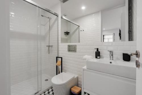 La salle de bains blanche est pourvue d'une douche et de toilettes. dans l'établissement SUN CHARMING APARTMENT, à Porto