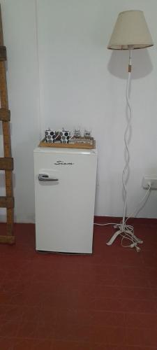 a small white refrigerator sitting next to a lamp at Residencial Villalobos in Eldorado