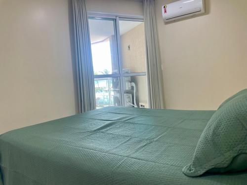 ein Schlafzimmer mit einem grünen Bett und einem Fenster in der Unterkunft Ninho de Gaivotas 1 - O Resort ! in Rio de Janeiro