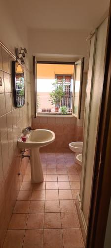 łazienka z umywalką, toaletą i oknem w obiekcie Le Fortezze w mieście Viterbo