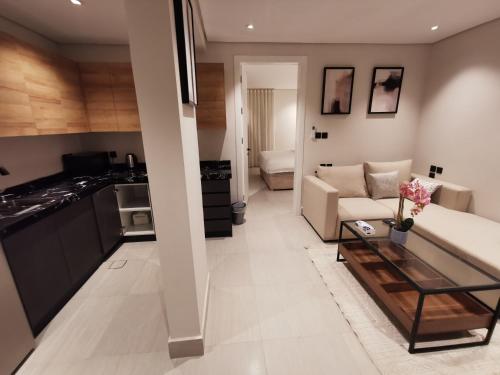 een woonkamer met een bank en een tafel bij شقة فاخرة بالقرب من البوليفارد دخول ذاتي a14 in Riyad