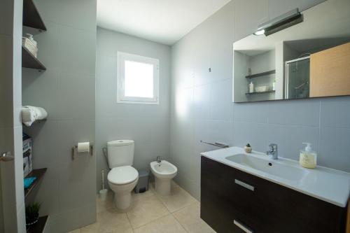 een witte badkamer met een toilet en een wastafel bij THE PHOTOGRAFIC FLAT in Málaga
