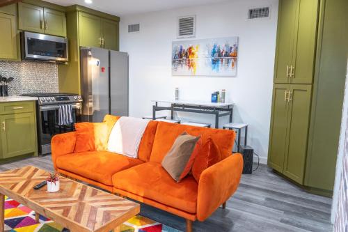 a living room with an orange couch and a table at Peaceful Villa in Los Angeles