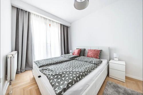 ein weißes Schlafzimmer mit einem großen Bett und einem Fenster in der Unterkunft Apartman Gold Oasis, self service check-in in Zagreb