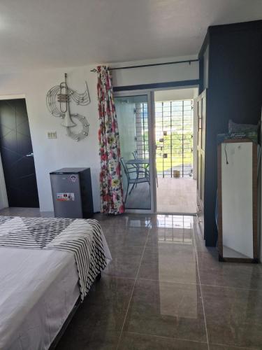 1 dormitorio con 1 cama, nevera y patio en Boonoonoonous en Kingston