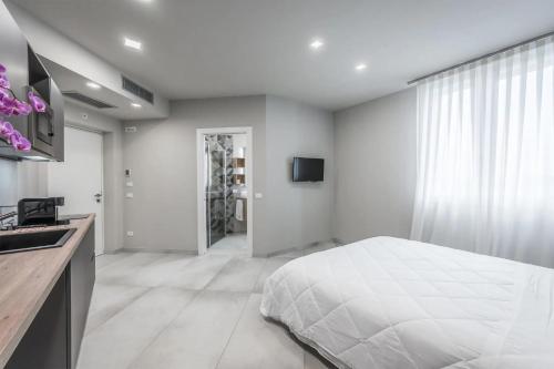 a white bedroom with a bed and a sink at Borgo degli Ulivi in Formigine