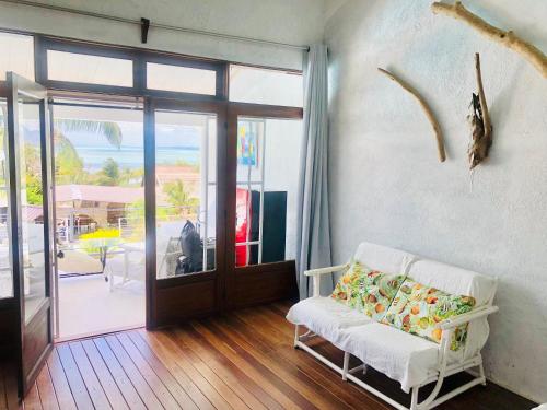 a living room with a white couch and a sliding glass door at Ma Vie La in Le Morne