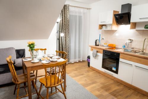 een keuken en een woonkamer met een tafel, een keuken en een eetkamer bij Apartamenty ,,Górska Strefa'' Czorsztyn in Czorsztyn