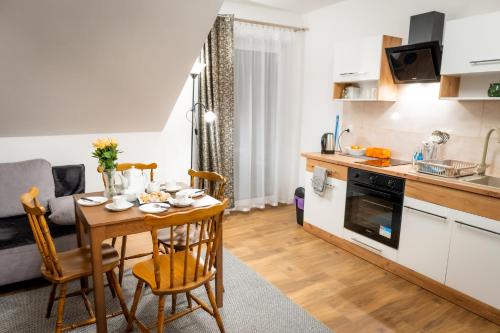 a kitchen and living room with a table and a kitchen and a dining room at Apartamenty ,,Górska Strefa'' Czorsztyn in Czorsztyn