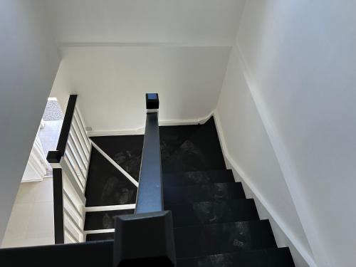 a staircase in a house with white walls and black stairs at NEW Luxury VILLA CapEstate Saint Lucia Ocean View in Cap Estate