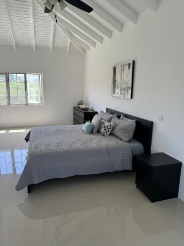1 dormitorio con 1 cama en una habitación blanca en NEW Luxury VILLA CapEstate Saint Lucia Ocean View en Cap Estate