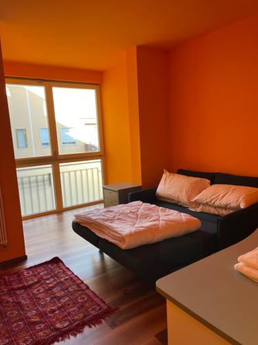 two beds in a room with orange walls at Cà Torre apartment in Mestre