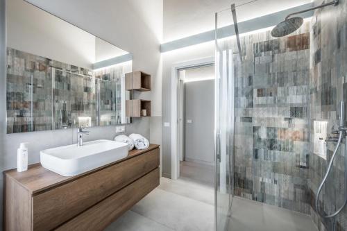 a bathroom with a sink and a glass shower at Borgo degli Ulivi in Formigine