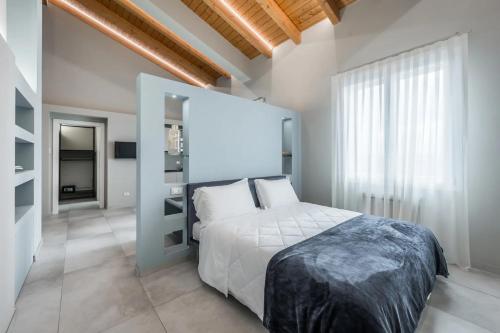 a bedroom with a white bed and a large window at Borgo degli Ulivi in Formigine