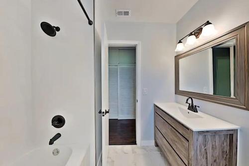 y baño con lavabo, espejo y ducha. en Heart of NPB, en North Palm Beach