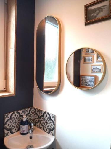 a bathroom with two mirrors and a sink at Joli T2 Saint-Brieuc entre port et centre WiFi gratuit in Saint-Brieuc