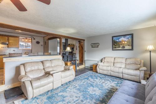 a living room with two couches and a kitchen at Cedars Cabin in Creede