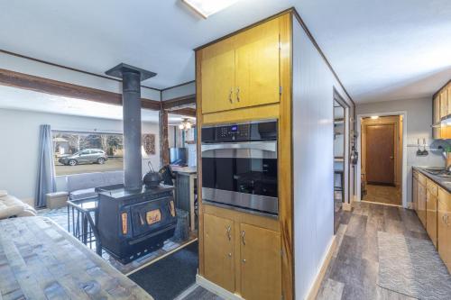 a kitchen with a stove and a living room at Cedars Cabin in Creede