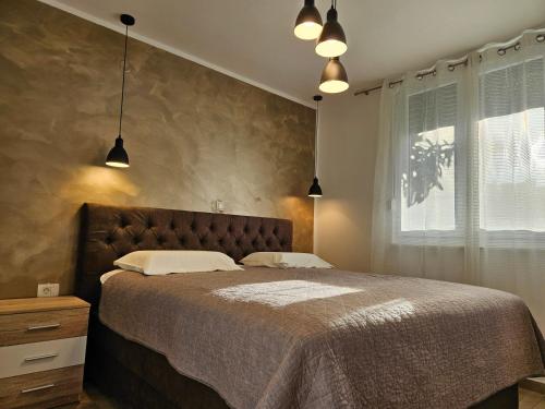 1 dormitorio con 1 cama grande y 2 luces colgantes en Deluxe Apartment near the Bridge, en Zadar