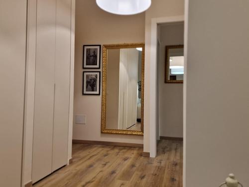 a room with a mirror and a hallway with wood floors at Guest House Canalis 17 in Oristano