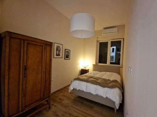 a bedroom with a bed and a cabinet and a window at Guest House Canalis 17 in Oristano