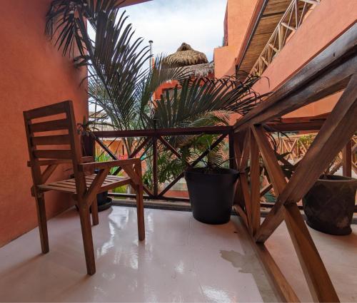 a wooden chair sitting on a balcony with plants at Casa Pepe in Sayulita