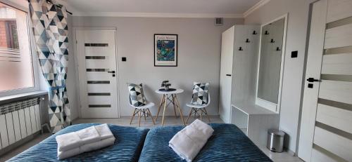 sypialnia z łóżkiem, stołem i krzesłami w obiekcie Apartament Wileńska 15 w Sejnach