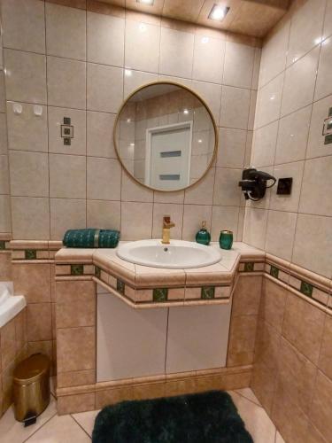 a bathroom with a sink and a mirror at Apartament Wileńska 15 in Sejny