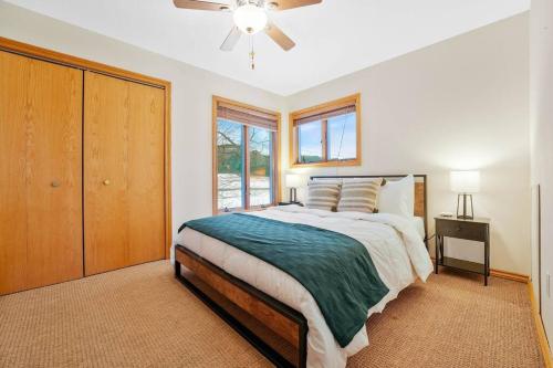 Schlafzimmer mit einem Bett und einem Deckenventilator in der Unterkunft Mountain Cabin overlook Boyne near Nubs W/ Hot Tub in Harbor Springs