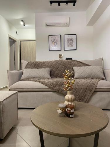 a living room with a couch and a table at Morpheus boutique apartment in Preveza