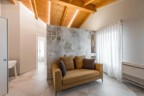 un sofá en una sala de estar con una pared en Borgo degli Ulivi, en Formigine