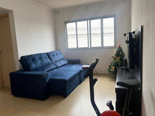 a blue couch in a living room with a christmas tree at Apartamento para Eventos Autódromo de Interlagos ou região in Sao Paulo