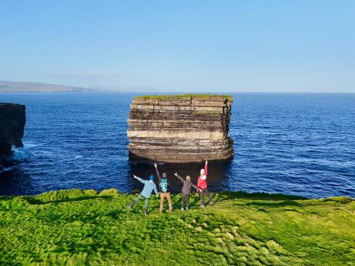 a group of people standing on a rock in the ocean at Ceide Glamping in Ballycastle