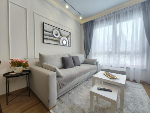 a living room with a couch and a table at Apartman Primus Zlatibor sa bazenom,spa&wellness centrom-Velika recepcija 125 in Zlatibor