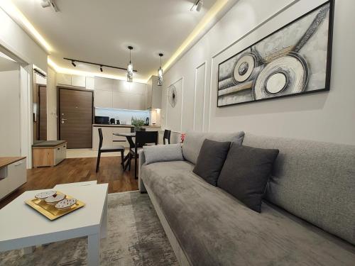 a living room with a couch and a table at Apartman Primus Zlatibor sa bazenom,spa&wellness centrom-Velika recepcija 125 in Zlatibor