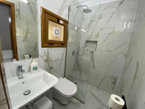 a bathroom with a sink and a toilet and a shower at Hotel Martini in Vlorë