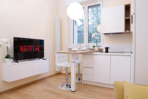 cocina con mesa y TV en una habitación en Botero Luxury Apartment Vicino Arco della Pace en Milán