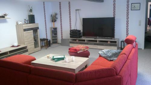 a living room with two red couches and a television at Unseburger Brauhaus GmbH Ferienwohnung 5 in Unseburg